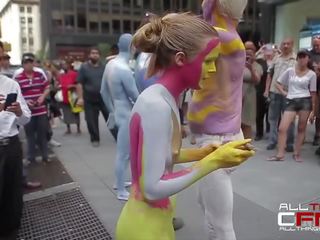 Group of naked people get painted in front of publ