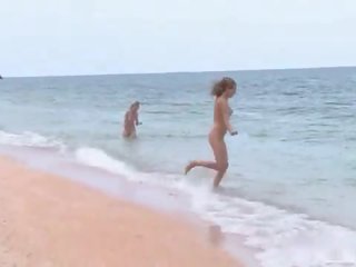 3 nudists jogar em o praia